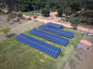Visão de cima dos painéis solares em uma área rural